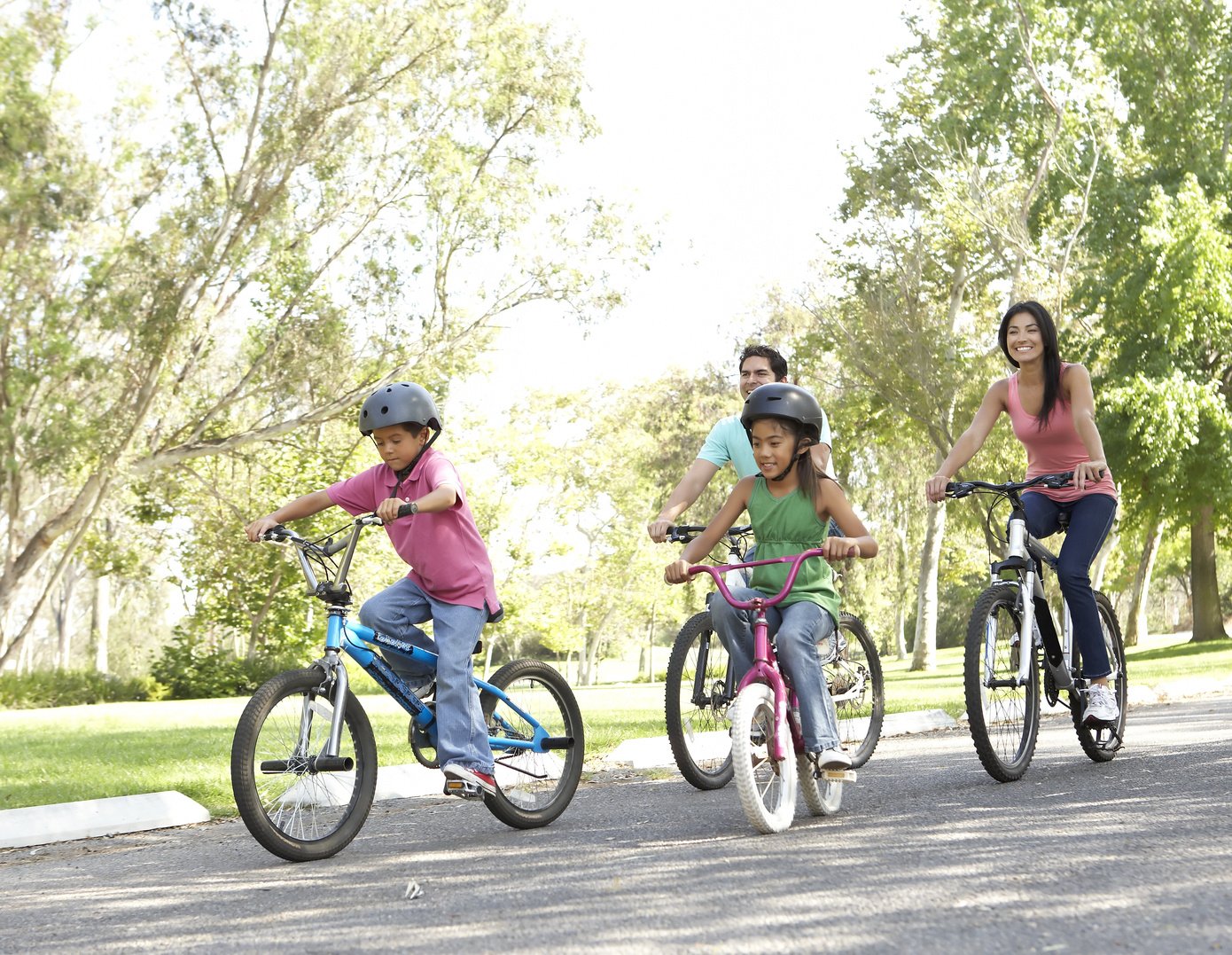 Young Family Riding Bikes in Park